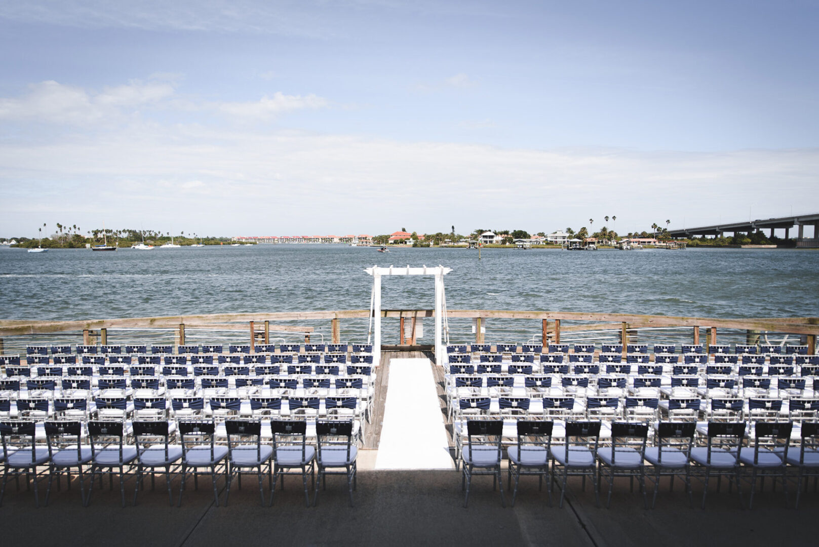 A wedding ceremony with chairs and an aisle.
