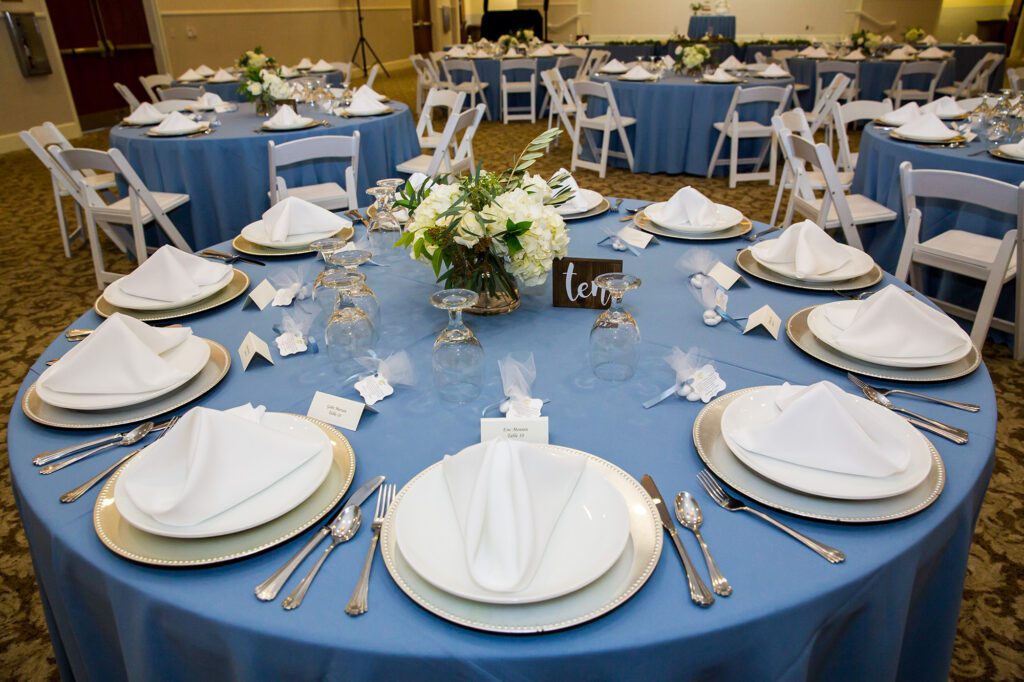 A table set with plates and silverware for a wedding.