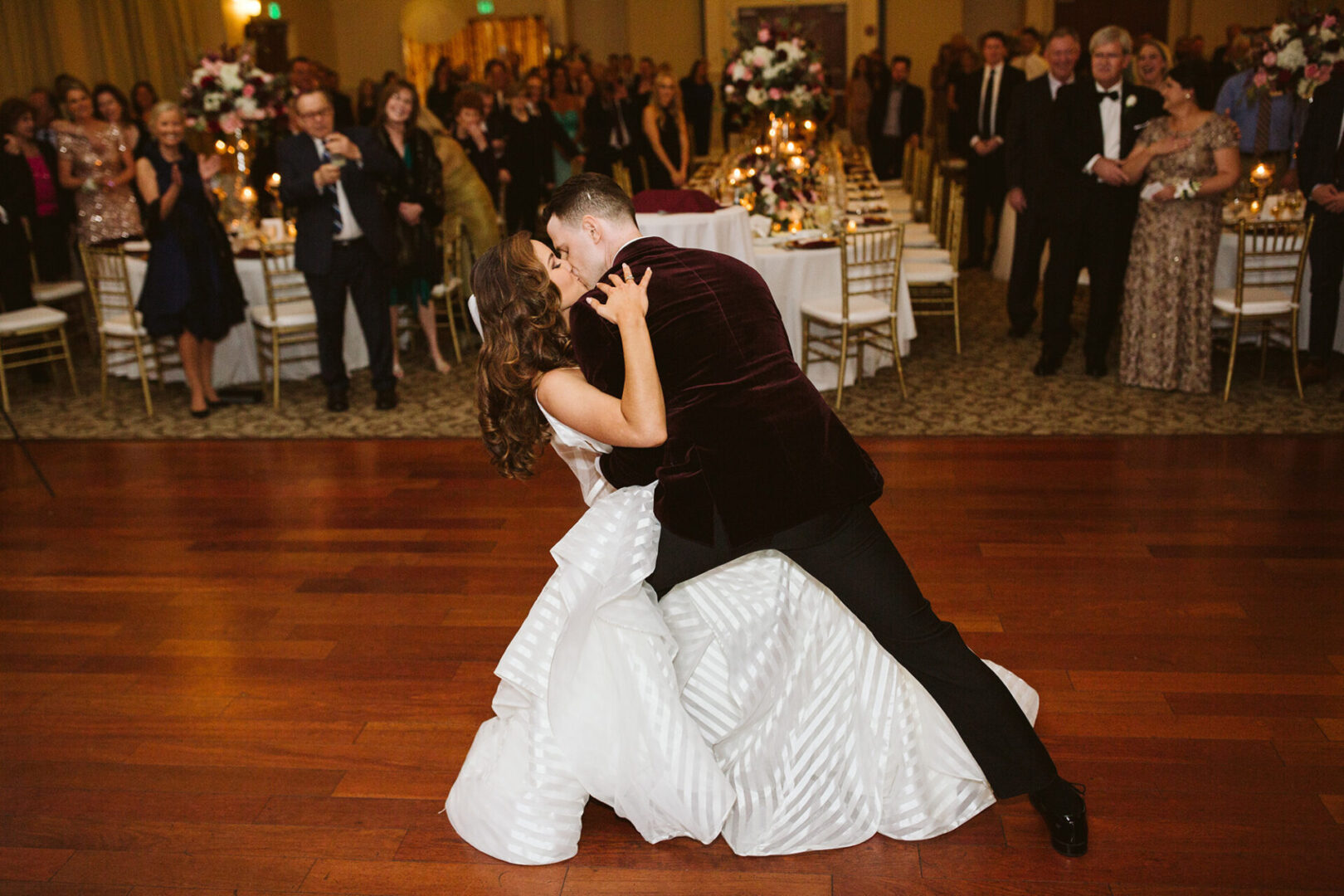 A bride and groom kissing on the dance floor.