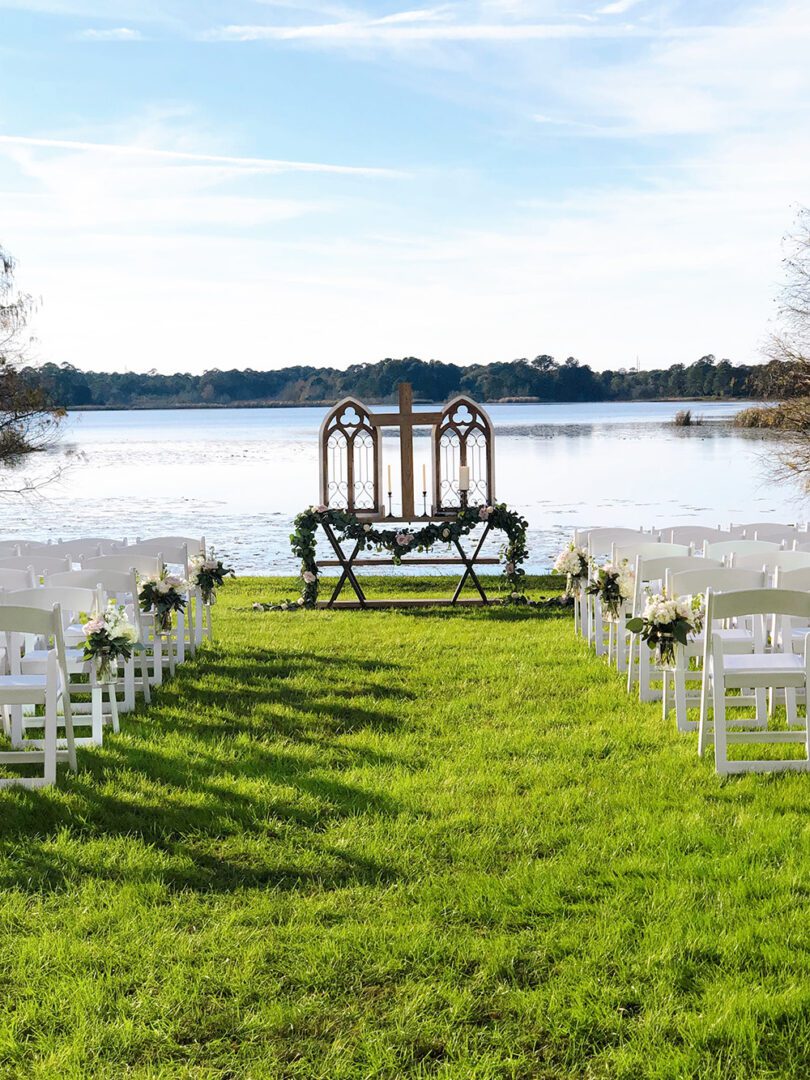 A wedding ceremony with chairs and benches in the grass.