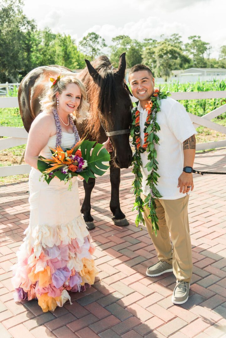 A man and woman standing next to a horse.