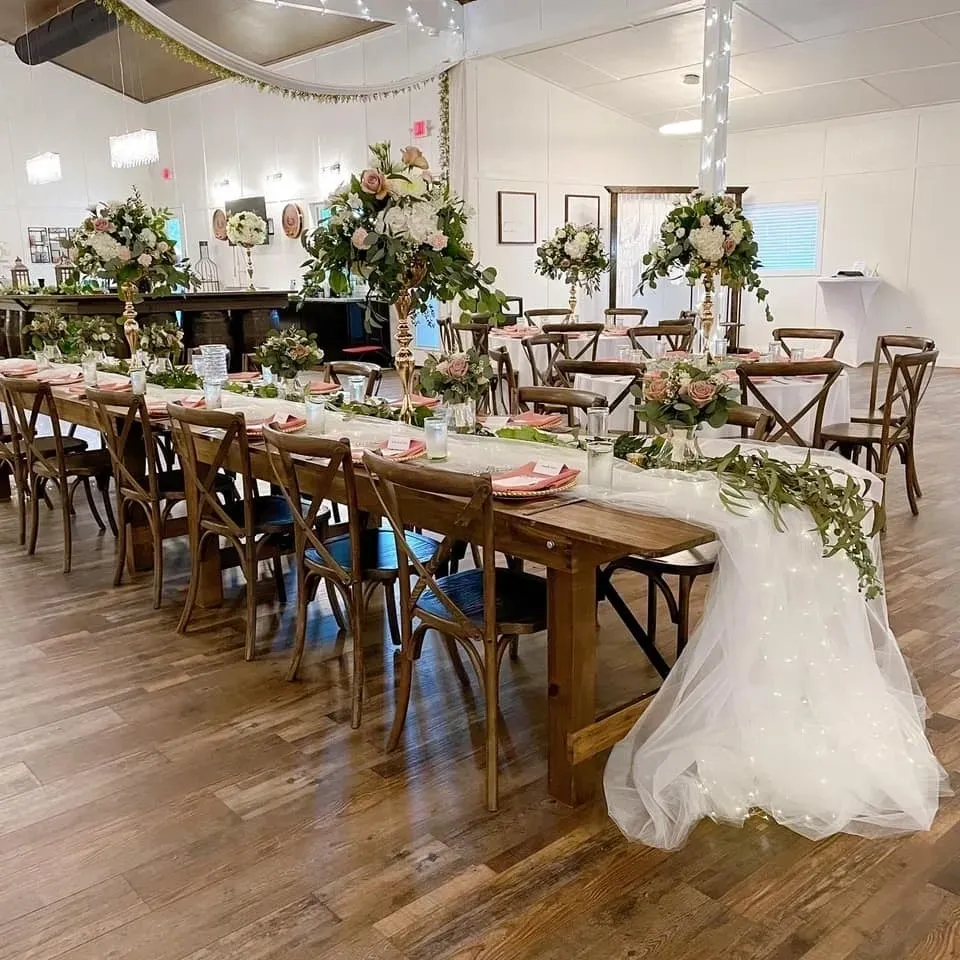 A long table with chairs and flowers on it