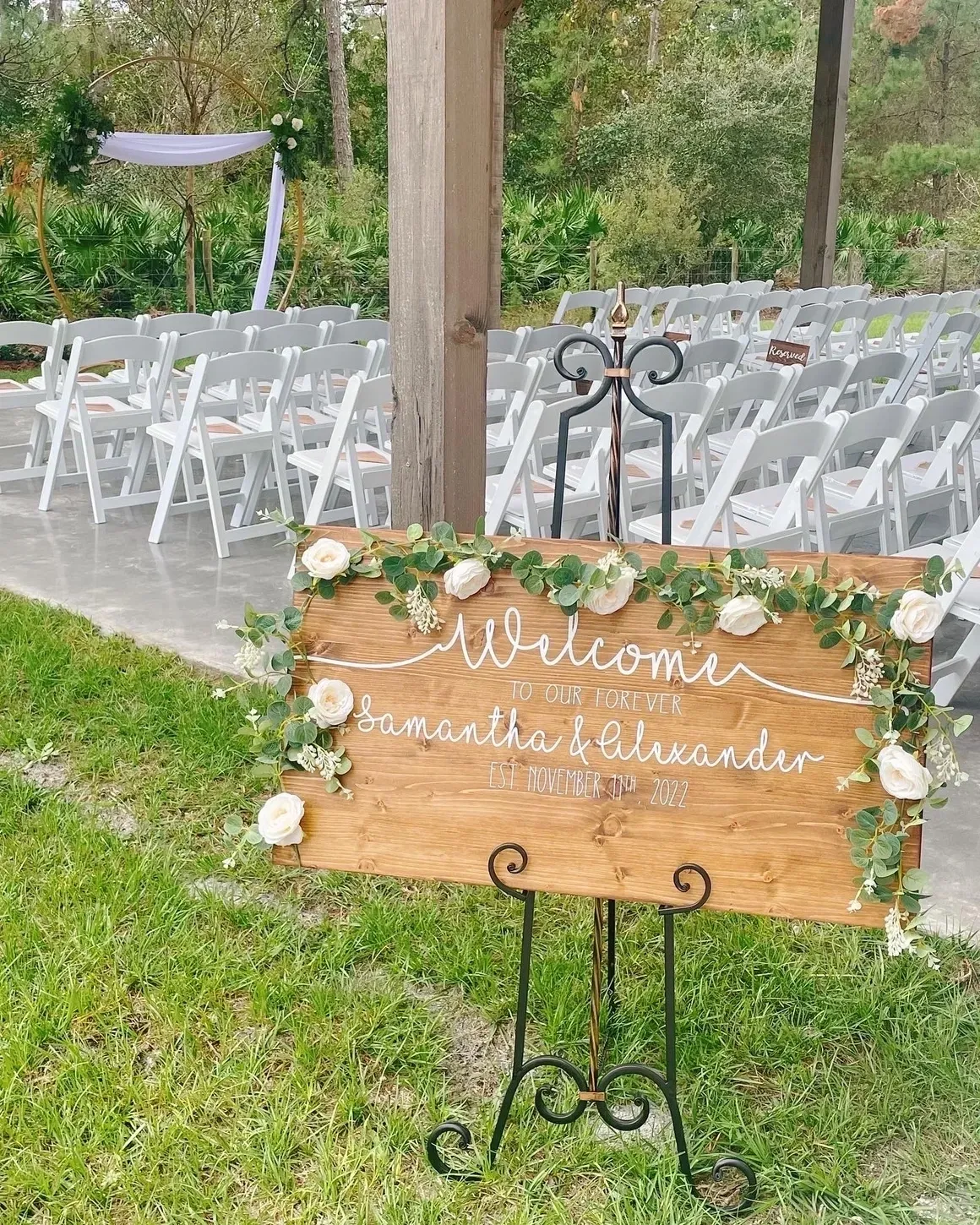 A wooden sign with white flowers on it