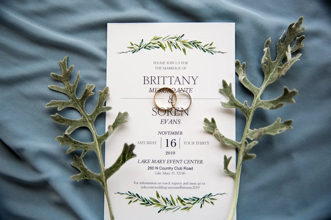 A wedding invitation with two rings on top of it.